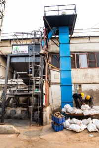 Briquette crusher bucket elevator fuel handling system